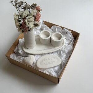 תקריב של אבן לבנה מעוצבת עם חריטת שמות ותאריך אישי כחלק ממארז Maor